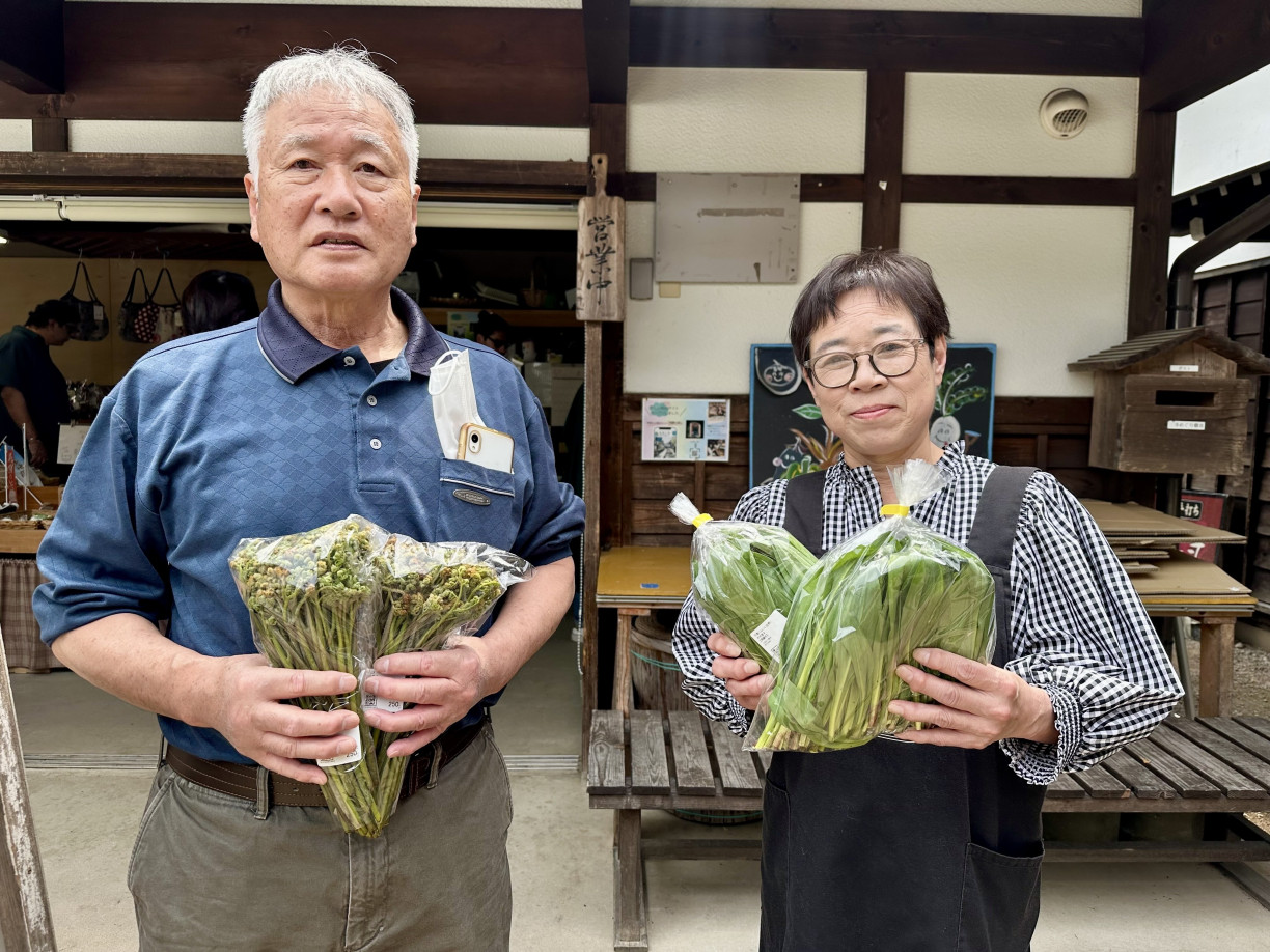 Ms. Kuyama and her coworker holding their favorite vegetables
