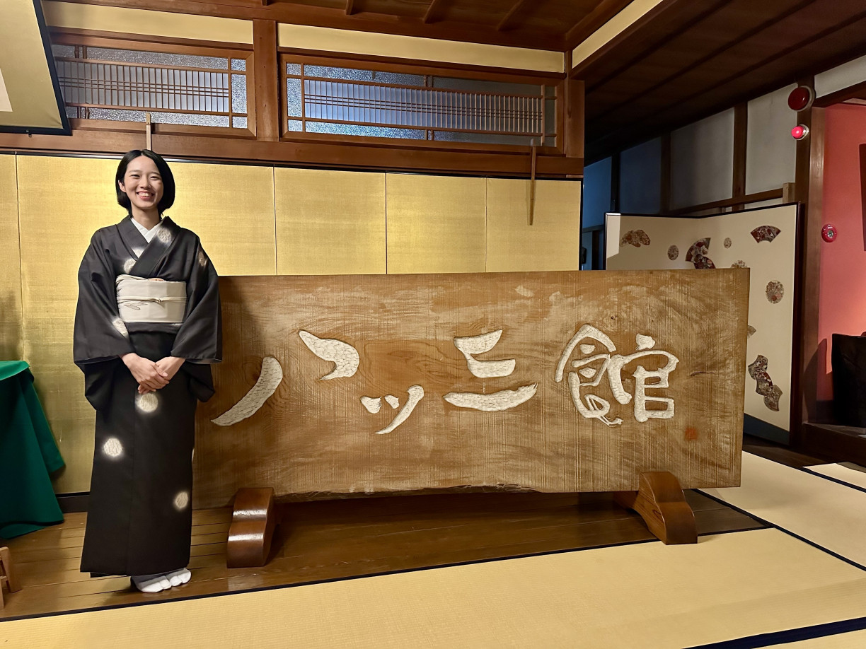 Ms. Kanako in front of Yatsusankan’s entrance sign